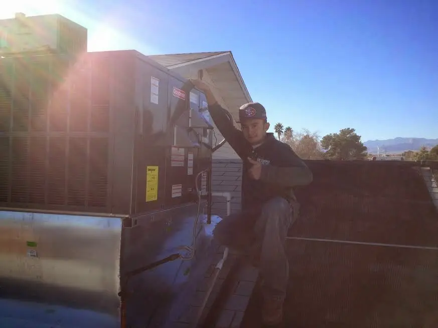 HVAC technician performing AC Tune-Up on a rooftop unit in Lakeside